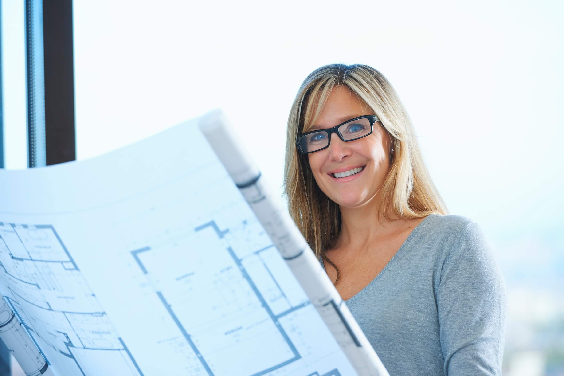 Planerin mit Architektenplan in der Hand